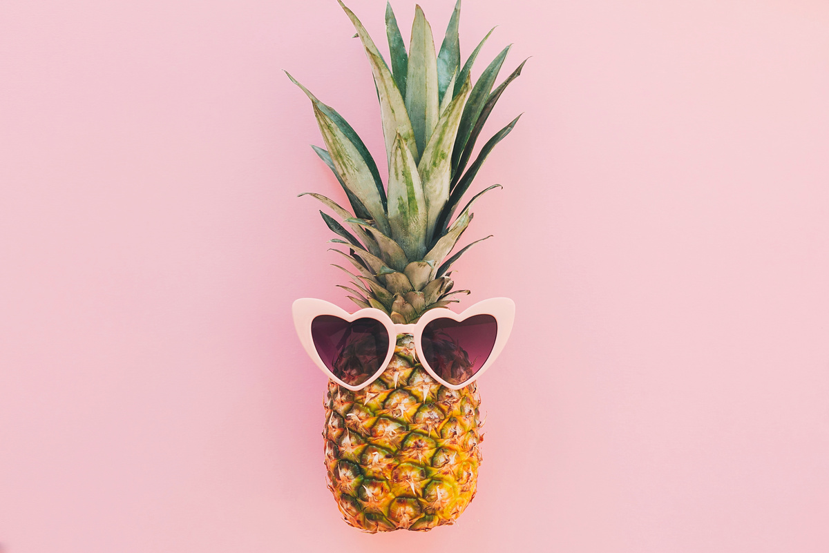 Stylish Pineapple in Pink Sunglasses on Trendy Pink Paper Backgr
